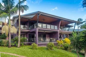 a purple house with palm trees in front of it at Anchorage 4 & Buggy Hamilton Island in Hamilton Island