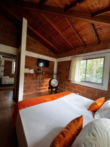 a bedroom with a large bed and a window at Yarumito Finca Hotel Cabaña Narciso in Barbosa