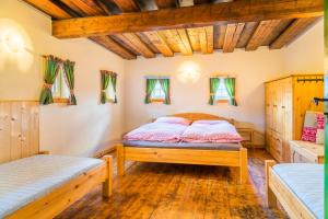 a bedroom with two beds and windows at Almhütte Brandgut in Mühlbach am Hochkönig