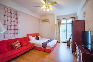 sala de estar con sofá rojo y TV en Hualien Travel en Dahan