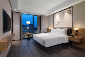 Postel nebo postele na pokoji v ubytování Fuzhou Mawei Yiho Hotel