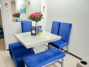 stół i niebieskie krzesła w poczekalni w obiekcie Exclusiva Casa con Alberca w mieście Bata