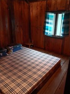 a large bed in a wooden room with a window at Ba Be Retreat in Bak Kan