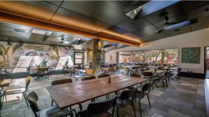 a restaurant with a large wooden table and chairs at The Royal Hotel Bungendore in Bungendore