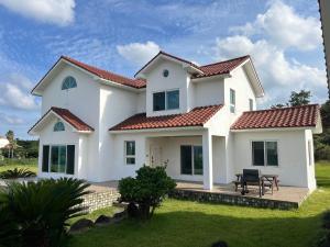 ein weißes Haus mit einem roten Dach in der Unterkunft tebaz in Jeju-do