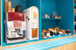 Una máquina de café sobre un mostrador con pasteles. en Kyriad ECO - Nevers Nord Varennes Vauzelles, en Varennes Vauzelles