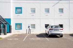 Un coche blanco estacionado en un estacionamiento frente a un edificio. en Kyriad ECO - Nevers Nord Varennes Vauzelles, en Varennes Vauzelles 28 fotos más