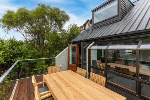 an open deck with a wooden table and chairs at Lodges 6 - Lake views and close to town in Queenstown +4 photos
