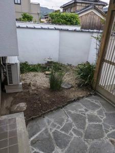un cortile con una recinzione bianca e un giardino di 漁師宿三浦屋秀栄丸 a Shōdoshima