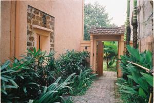 a walkway leading to a building with an open door at Moncada Motel Ba Vi in Hà Lộc