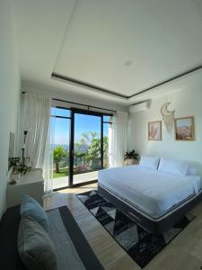 a bedroom with a large bed and a large window at Casa Revanaka Ciumbuleuit Bandung in Bandung