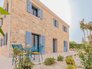 a patio with chairs and a table in front of a building at Seafront Villa Adriatica with pool in Dobropoljana