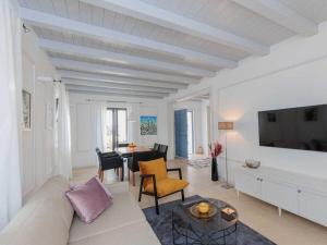 a white living room with a couch and a table at Seafront Villa Adriatica with pool in Dobropoljana