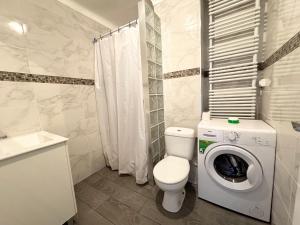 Un baño con inodoro y lavadora. en Apartsalou Bilbao, en Salou