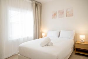 una camera da letto bianca con un grande letto bianco e una finestra di Tamworth Country Stay on Goonoo a West Tamworth