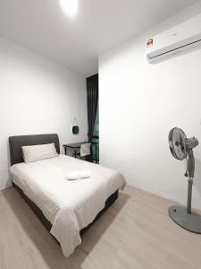 a white bedroom with a bed and a fan at Gem Suites Apartment in Kuching
