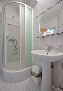 ein weißes Badezimmer mit Waschbecken und Dusche in der Unterkunft Hotel Luna in Žiar nad Hronom + 19 Fotos