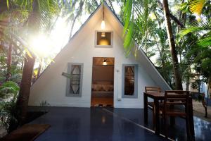 卡纳科纳Temple Garden的一个带桌子和椅子的三角形屋顶的房子