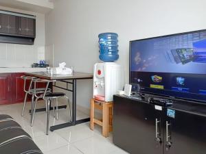Televiisor ja/või meelelahutuskeskus majutusasutuses COZY 2BR Pinewood Apt Jatinagor with Wi-Fi n Pool by 2ndHome