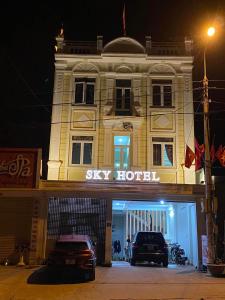 Dos coches aparcados frente a un hotel por la noche. en Sky Hotel MC - by BAY LUXURY, en Mộc Châu