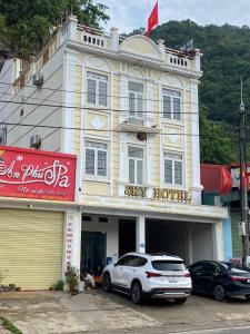 Un coche blanco aparcado delante de un edificio en Sky Hotel MC - by BAY LUXURY, en Mộc Châu