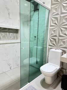 a bathroom with a toilet and a glass shower at Casa em Foz do Iguaçu in Foz do Iguaçu +13 photos