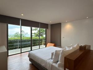 a bedroom with a large bed and a large window at 4bedroom Villa Siray Beach Front in Phuket Town