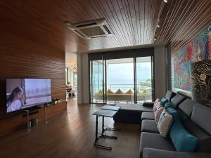 a living room with a couch and a flat screen tv at 4bedroom Villa Siray Beach Front in Phuket Town