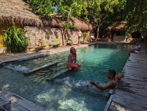 a man and a woman sitting in a swimming pool at Hiru Villas and Kitesurfing in Kalpitiya