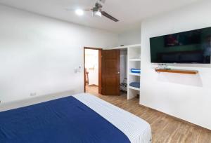 a bedroom with a blue bed and a flat screen tv at Casa a Mallorca, a 3 cuadras del malecón La Paz in La Paz