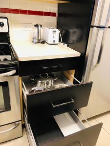 a kitchen with a black refrigerator and a stove at 5th Floor 1-Bedroom Condo with Parking in Calgary +2 photos