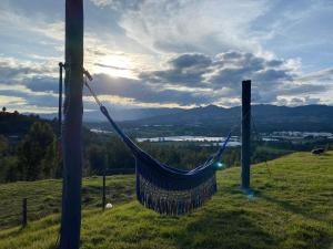 a hammock hanging from a pole on a hill at Finca La Condalia in Nemocón +31 photos