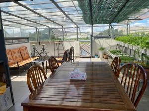 ein Holztisch und Stühle auf einer Terrasse in der Unterkunft Creme Homestay Đà Lạt in Khu Chi Lăng + 35 Fotos
