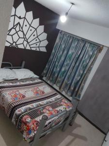 a small bedroom with a bed with a curtain at Renta de Habitaciones en muy buena ubicación in San Juan Xilotzingo