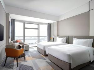 宝山区上海伊敦康得思酒店Cordis Shanghai Seaworld的一间有两张床和一台电视的酒店房间