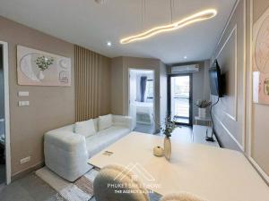 a living room with a couch and a table at Tower condo Rawai Phuket in Ban Klang