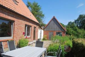 a brick house with a table and chairs in a yard at Gästehaus Rohde in Rothenhaus