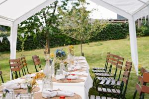 a long table under a white tent with chairs at Gästehaus Rohde in Rothenhaus