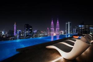 a white and black chair sitting on a rooftop at night at Atelier KLCC in Kuala Lumpur