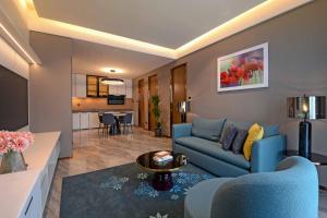 a living room with a blue couch and a table at Atelier KLCC in Kuala Lumpur