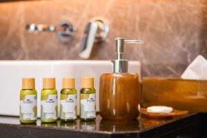 a group of four bottles of soap on a counter next to a sink at Atelier KLCC in Kuala Lumpur