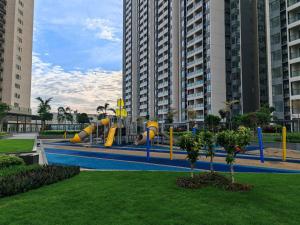 a playground with a slide in a park with tall buildings at R&F Princess Cove JB Apartment Suites By SC Homestay in Johor Bahru