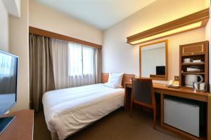 東京にある第一イン池袋のベッドと机があるホテルの部屋