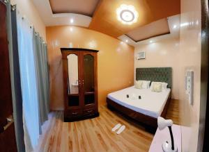 a small room with a bed and a bathroom at Rb's Three Storey House in Zamboanga
