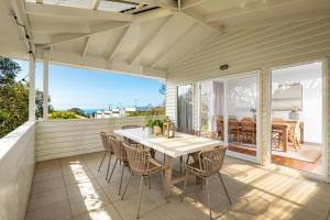 托基Luxury 4 BDR beach home with sea views - sleeps 12的阳台上配有桌椅的露台