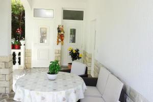 a white table with white chairs and a plant on it at Apartment Daisy- excellent location close to Rab in Rab
