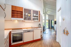 a kitchen with white cabinets and a stove top oven at Strandblick - Dorf 1 Ferienhaus 07 in Priwall