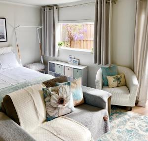 NorlaneMEPLE, Tiny Home, Pets, Walk2Food, WiFi, Bfast, Private, Serene的一间卧室，里面有一张床、一张沙发和一把椅子