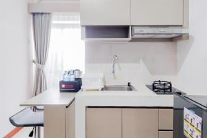 a kitchen with a sink and a counter top at Homey and Modern 2BR at Loftvilles City Apartment By Travelio in Tangerang