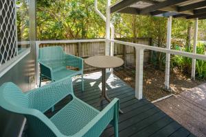 a porch with blue chairs and a table on it at Moffat Beach Magic Family and Pet Friendly Oasis in Caloundra +22 photos